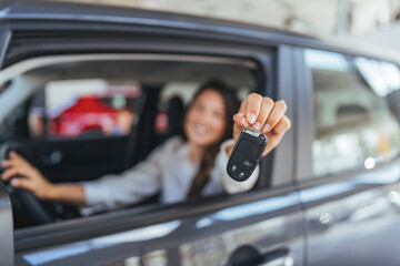 Smiling Driver In Car Holding Key Fob Up For Photo Shoot