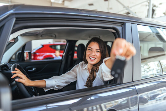 Happy Woman In Car Smiling Behind The Wheel, Showing Keys In Modern SUV