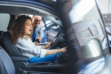 Excited Woman Drives Car During Test Drive While Dealer Assistant Watches and Guides