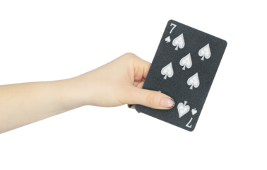 playing card spades 7 in hand, outstretched hand with black playing card isolated from background