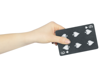 playing card spades 6 in hand, outstretched hand with black playing card isolated from background