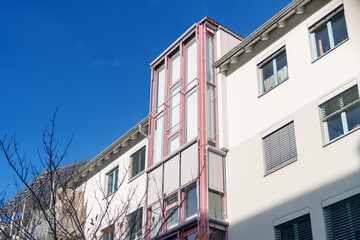 Obraz premium Modern architectural design featuring a glass elevator in an urban setting under a clear blue sky