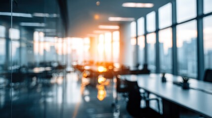 Blurred modern office interior with bright sunlight streaming through windows.