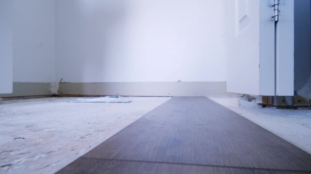 A Man And Woman Install Vinyl Laminate In Their Apartment Using Click-Lock System, Representing Family Renovation Effort.Family Laying Laminate Flooring Together DIY Home Project 