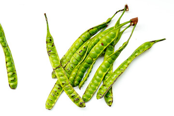Fresh Petai or stink beans isolated on a white background. These vibrant green pods are a key...