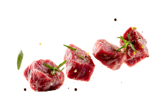 Fresh raw beef cubes seasoned with herbs and spices floating isolated on transparent background