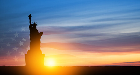 Statue of Liberty with american flag on background of sunset sky. Greeting card for Independence Day. USA celebration. © hamara