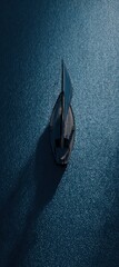 Miniature toy sailboat casting a long shadow on a deep blue textured surface, evoking themes of journey, tranquility, and isolation