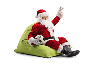 Santa Claus sitting on a bean bag with a football and and cheering