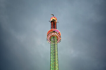 Colorful drop tower Ride against stormy sky