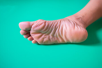 Feet of a woman on a green background with copy space.
