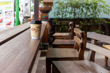 Coffee cup on wood table in coffee shop background