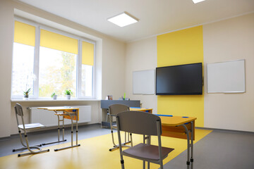 Classroom with yellow desks and chairs at school