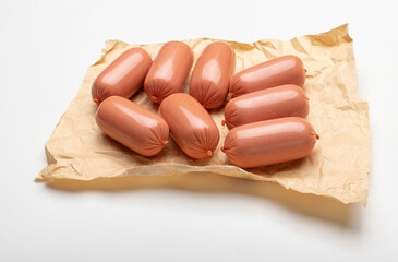 Eight Plump Sausages on Rustic Kraft Paper A Culinary Stock Photo for Kitchen and Cooking Themes