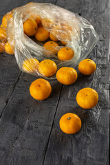 Fresh Oranges Spilling from Plastic Bag onto Rustic Wooden Table
