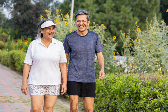 Smiling Indian Senior Couple Enjoying a Happy Conversation While Walking in the Park