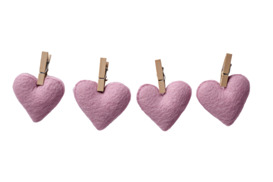 Four small, soft, pink felt hearts, each attached to a wooden clothespin, arranged in a horizontal row against a black background