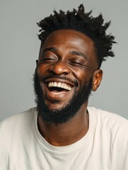 Obraz premium handsome unshaven young darkskinned male laughing out loud at funny meme he found on internet smiling broadly showing his white straight teeth positive human facial expressions and emotions no logos 