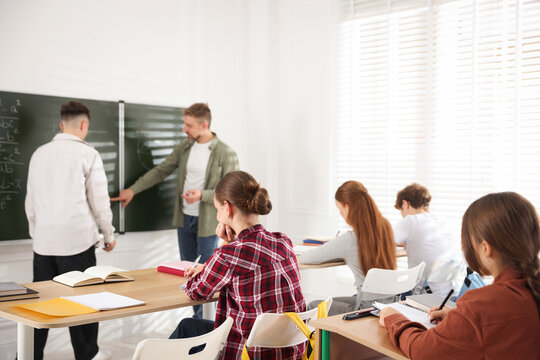 Teacher and students during lesson in classroom, selective focus - Powered by Adobe