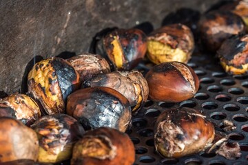 Roasted chestnuts sold at a street vendor during winter in a bustling urban market
