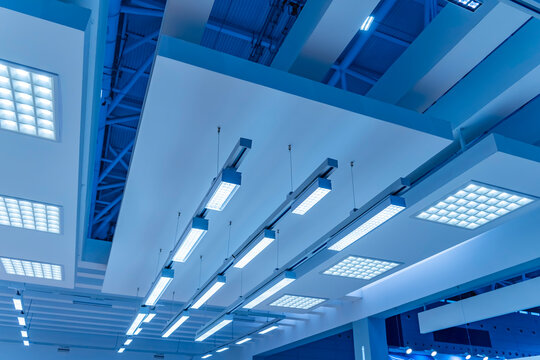 Directional LED lights on rails under the ceiling in a modern warehouse, shopping center building, office or other commercial real estate object.