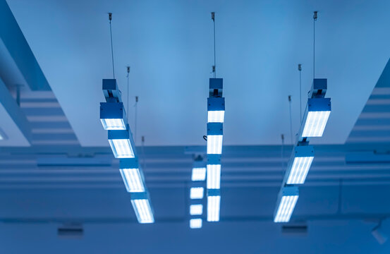 Directional LED lights on rails under the ceiling in a modern warehouse, shopping center building, office or other commercial real estate object.