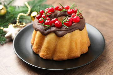 Tasty cake with cranberries and Christmas decor on wooden table, closeup