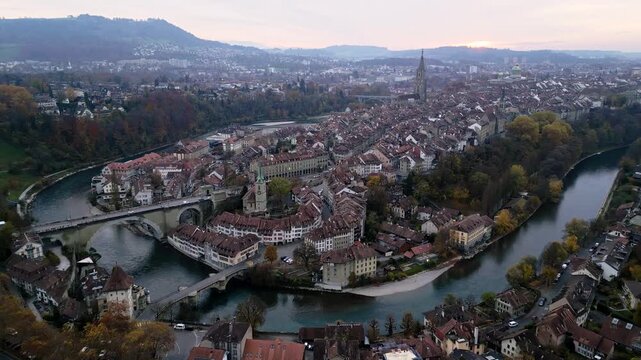 Aerial view of Bern's old town, with its iconic bridges spanning the turquoise Aare river, surrounded by buildings with red rooftops, Bern, Canton of Bern, Switzerland.