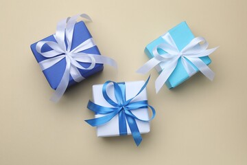Beautiful gift boxes on beige background, flat lay