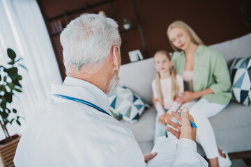 Obraz premium Doctor with clipboard offers support to loving mother and daughter at home during a health checkup