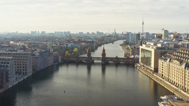 Aerial view of the Oberbaum Bridge standing majestically over the tranquil Spree river, with the iconic TV Tower rising above the cityscape, Berlin, Berlin, Germany.
