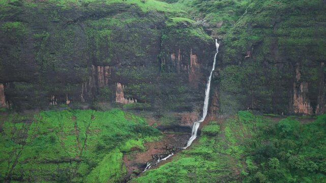 4K Slow motion shot of a waterfall falling from a cliff in Sahyadri mountain range during the monsoon season near Pune at Maharashtra, India. Scenic view of ring waterfall seen from Savlya Ghat. 