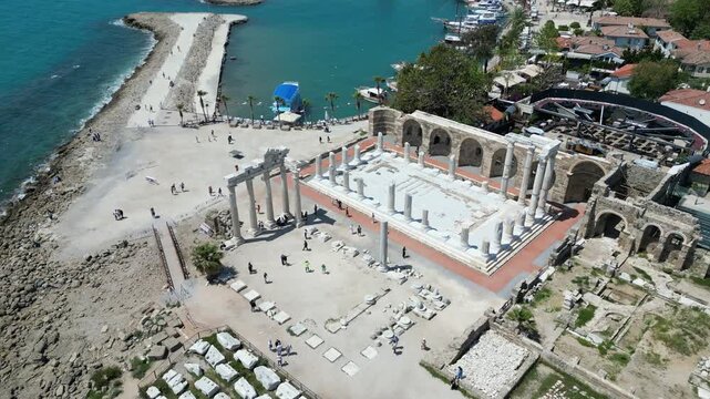 Aerial view of the Temple of Apollo juxtaposes ancient ruins against the turquoise sea, a vibrant scene of history and natural beauty, Side, Antalya, Turkey.