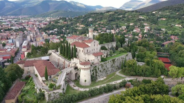 Aerial view of Brescia Castle with its stone walls and towers, nestled amidst green trees, overlooking the cityscape, Brescia, Lombardy, Italy.