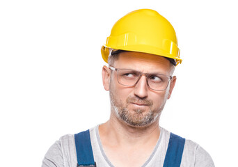 Strict construction worker thinks. Portrait of doubtful repairman with confusion face expression, isolated on white background. Careful construction worker, copy space for text. Craftsman