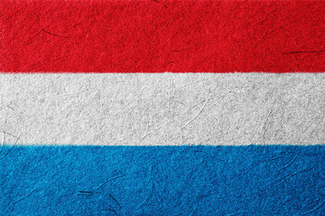 Striking tricolor horizontal banner image with bold red, white, and blue bands creating a sense of national identity and simple graphic design with a textured, artistic feel.