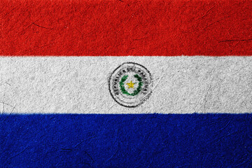 Textured representation of the Paraguay flag featuring horizontal bands of red, white, and blue, and the national emblem centered on the white band; evokes a sense of patriotism and