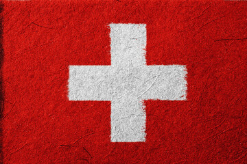 A textured red and white plus sign is presented in a stark, graphic style, evoking simplicity and boldness with its strong contrast and minimalist composition on a gritty surface look.