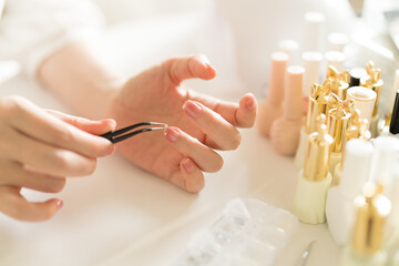 Use pliers to take a diamond and stick it on fingernail.