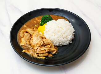 Enjoy delectable Japanese curry rice with tender pork, vibrant broccoli and crisp yellow pickles, a comforting and delicious meal for any occasion.