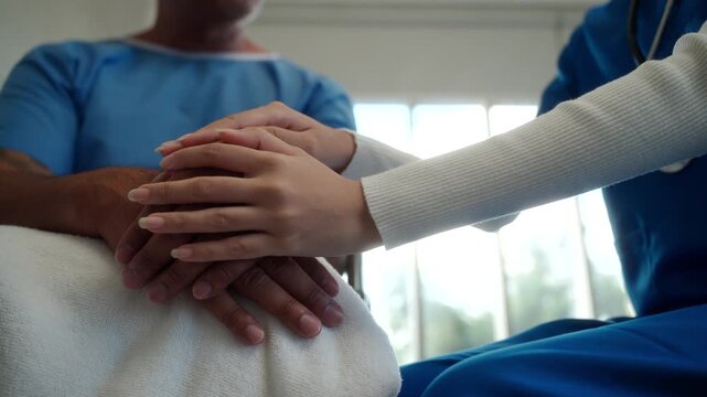 Close up of doctor woman holding patient hand who sitting on wheelchair to support cheering up and encourage in recovery ward hospital, doctor touching patients hand giving hope empathy wellness.
