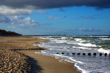 Sea breakwater and lighthouse at entrance to port Dziwnow, Poland