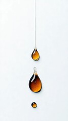 Three amber-colored liquid drops are suspended and falling against a clean white background, creating a sense of motion and purity.
