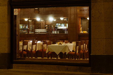 Elegant Empty Restaurant Interior at Night with Set Tables and Warm Ambient Lighting