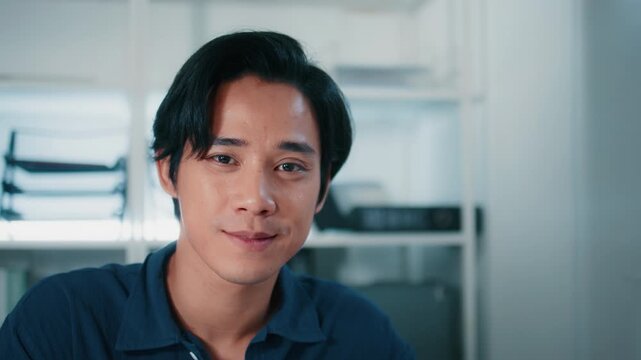 Portrait of Young Asian Businessman in office, Smiling Asian Male Employee looking at camera. Asian Business man working in office. Happy Casual Businessperson in modern workplace.