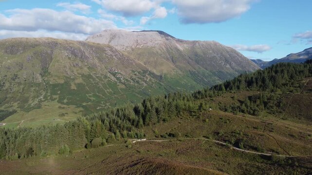 Aerial view of lush green mountains and a winding valley, showcasing nature's beauty with contrasting colors and textures, Fort William, Scotland, United Kingdom.