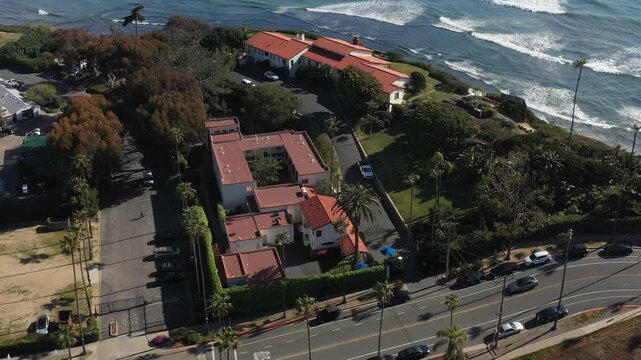 Aerial view of the Yogananda Ashram, a tranquil site with red-roofed buildings, green gardens, and palm tree-lined streets, Encinitas, California, United States.