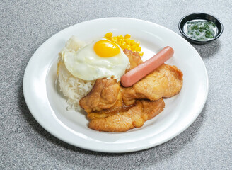 Hearty breakfast platter featuring fried egg, rice, chicken, sausage, and corn. A delicious and savory meal to start your day or enjoy any time.