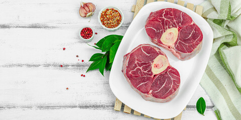 Raw ossobuco beef meat with spices and fresh herbs. Veal shank steak, traditional Italian ingredient