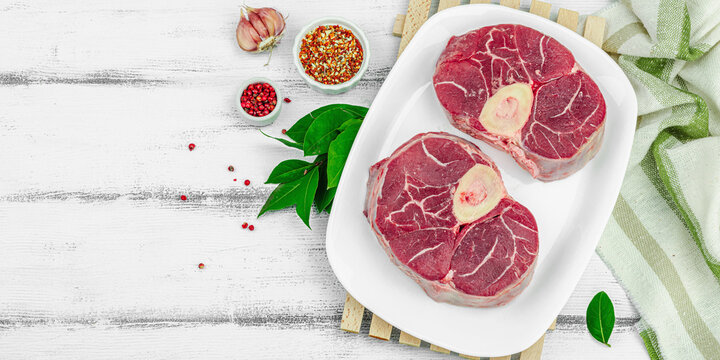 Raw ossobuco beef meat with spices and fresh herbs. Veal shank steak, traditional Italian ingredient